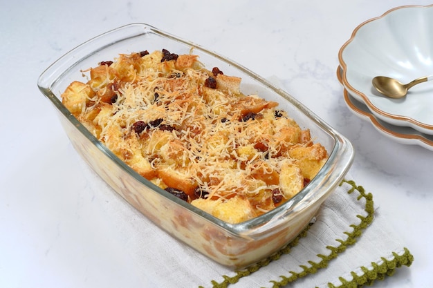 Homemade bread butter pudding with raisins and grated cheese as topping