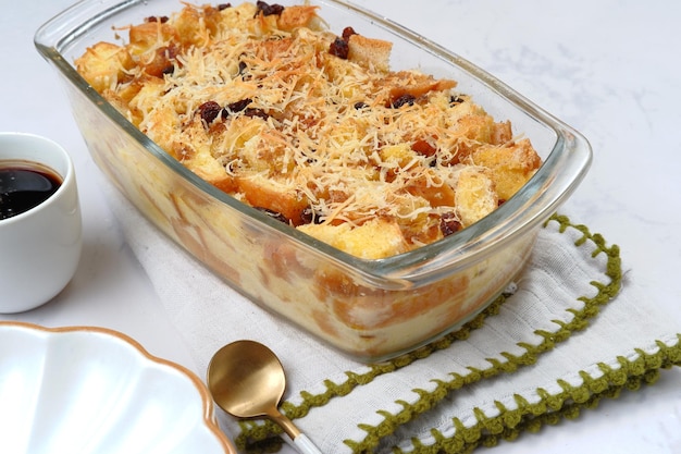 Homemade bread butter pudding with raisins and grated cheese as topping