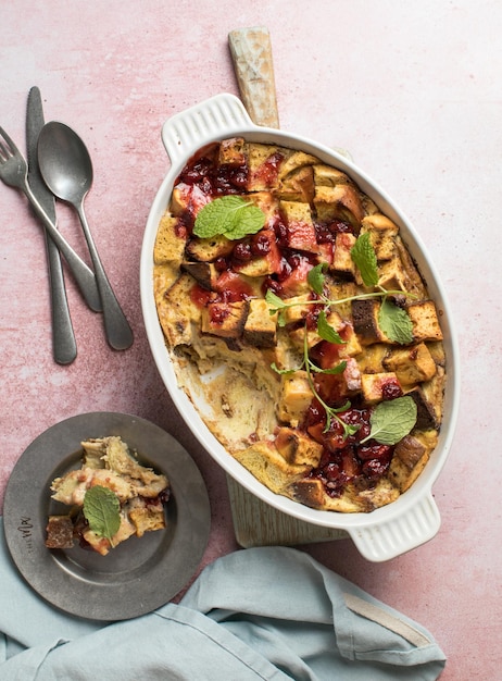 Homemade bread pudding with jam on a pink concrete background Selective focus copy space