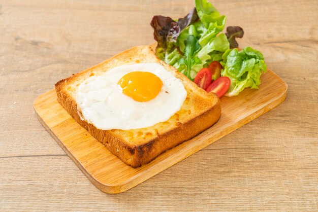 homemade bread toasted with cheese and fried egg on top with vegetable salad for breakfast