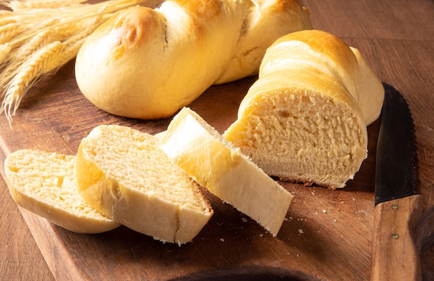 Homemade bread, two beautiful homemade breads one of them sliced ââon wood and a branch of wheat.