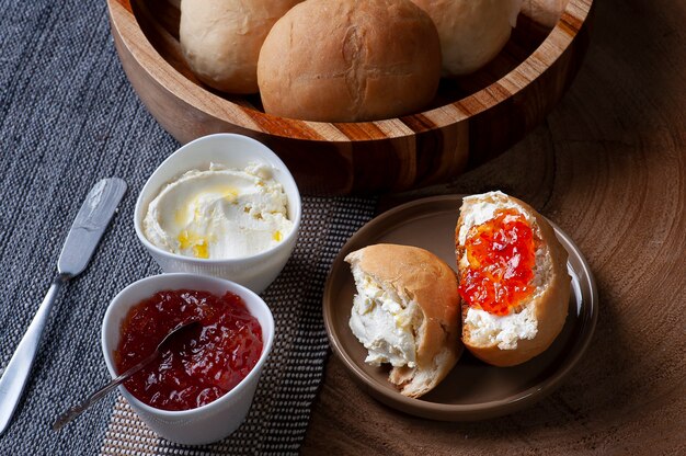 Homemade bread in a wooden bowl accompanied by curd and jam