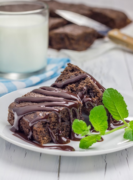 Homemade brownies with chocolate sauce and glass of milk