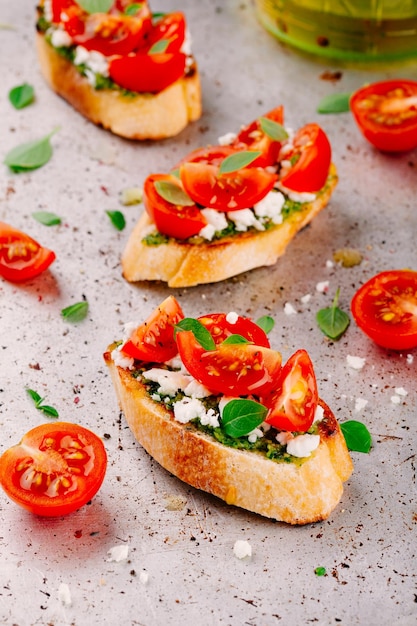 Homemade bruschetta with pesto sauce feta cheese tomatoes and basil