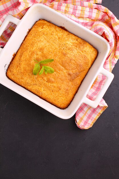 Homemade cake decorated with mint in white form on a black background