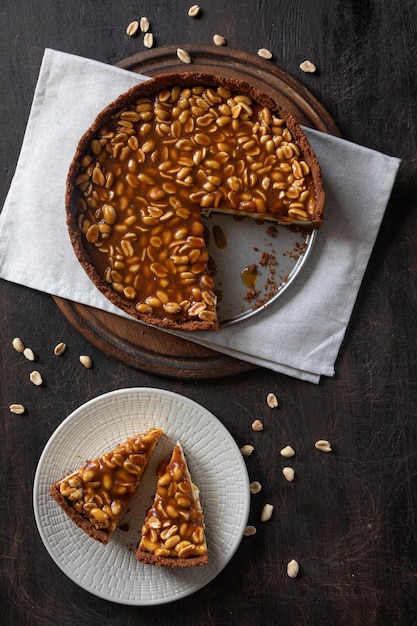 Homemade caramelpeanut cheesecake on a dark background Morning delicious bakery cake