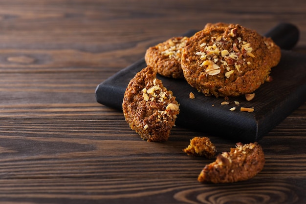 Homemade carrot cookies with nuts on a dark wooden board Sugar gluten lactose free vegan