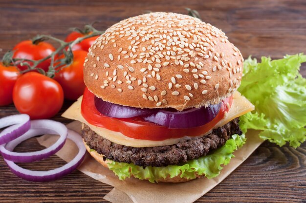 Homemade cheeseburger on brown wooden surface