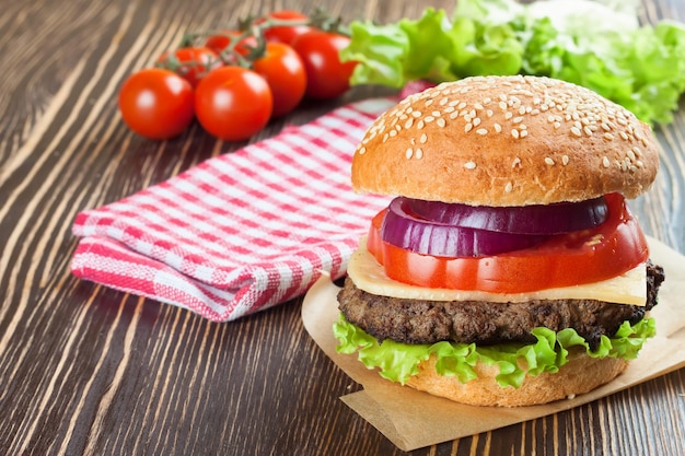 Homemade cheeseburger on brown wooden surface