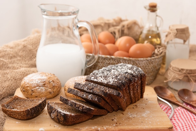 Homemade chicken eggs and freshly baked bread on a wooden table.