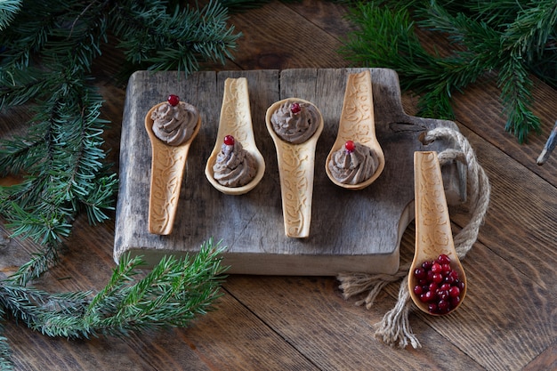 Homemade chicken liver pate with cranberry in edible shortbread spoons on old wooden cutting Board