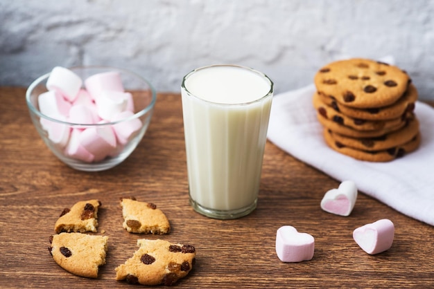 Homemade chip cookies with milk and air marshmallow on kitchen towel and wooden table Good morning Breakfast consept