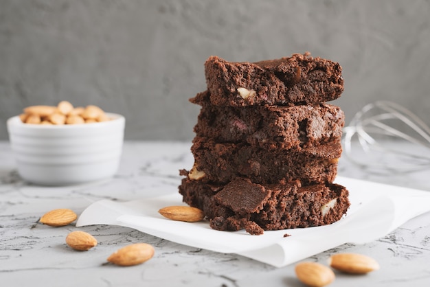 Homemade chocolate brownie cake baked with almond nuts and served on a baking paper