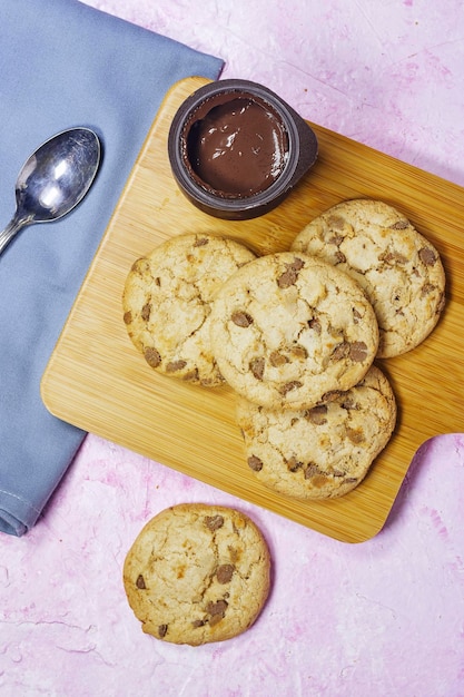 homemade chocolate chip cookies on cutting board with chocolate pudding