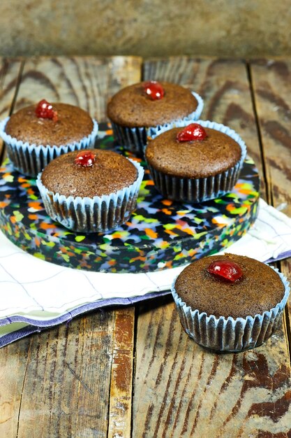 homemade chocolate nuts muffins decorated with candied cherry on wood table homemade chocolate nuts