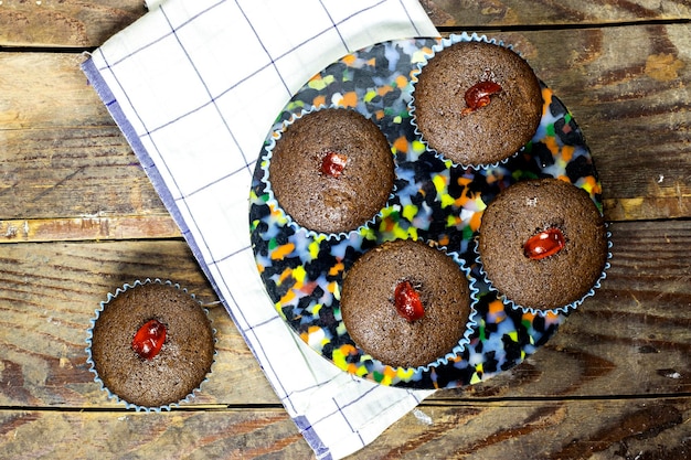 homemade chocolate nuts muffins decorated with candied cherry on wood table homemade chocolate nuts