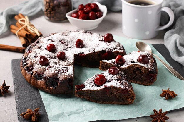 Homemade chocolate pie with cherries on a gray background Closeup