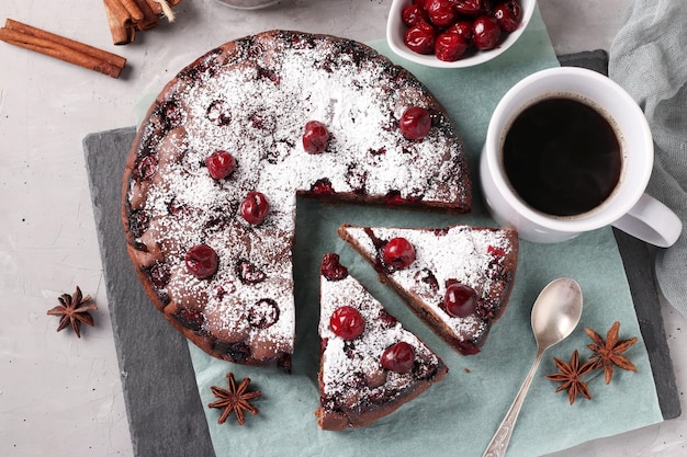 Homemade chocolate pie with cherries on a gray background View from above