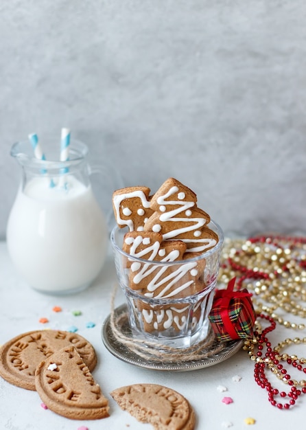 Homemade Christmas cookies a fir-tree in a glass, a jug with milk on a gray background