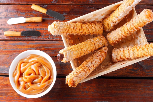 Homemade churros with multiple fillings in a basket on a rustic wooden table