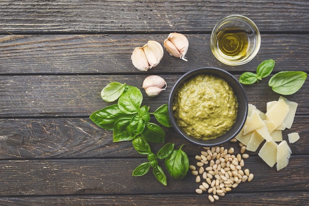 Homemade classic pesto sauce with ingredients fresh basil cheese garlic and pine nuts on wooden