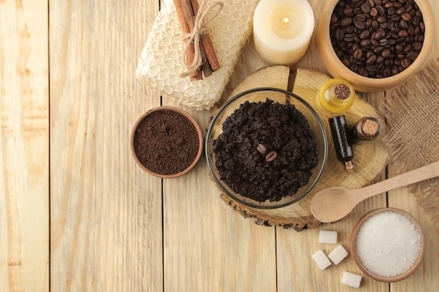 Homemade coffee scrub in the face and body bowl and various ingredients for making scrub on a wooden table spa cosmetics care cosmetics top view with space for text