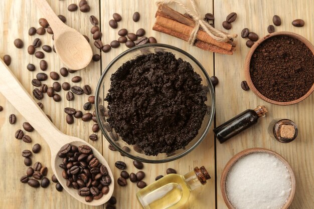 Homemade coffee scrub in the face and body bowl and various ingredients for making scrub on a wooden table spa cosmetics care cosmetics view from above