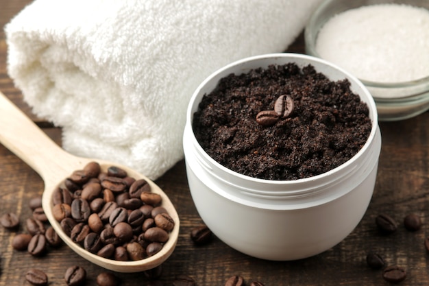 Homemade coffee scrub in a white jar for the face and body and various ingredients for making scrub.