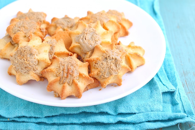 Homemade cookies with halva on a white plate. Blue background