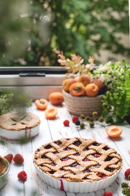 Homemade cooking bakery, summer berry pie with raspberry and apricots, rustic wooden table