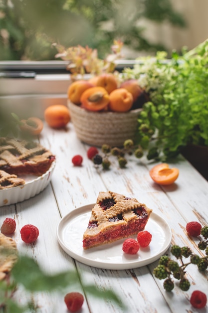 Homemade cooking bakery, summer berry pie with raspberry and apricots, rustic wooden table