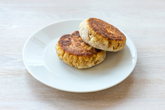 Homemade cottage cheese pancakes syrniki stack on plate on white table. Close up. Selective focus. Copy space