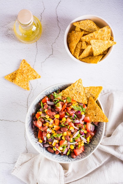 Homemade cowboy caviar traditional mexican vegetable salad and nachos in a bowl Top and vertical view