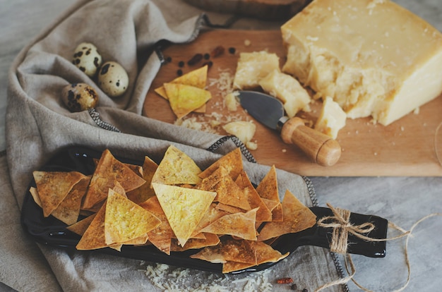 Homemade crispy chips with parmesan cheese made of Armenian flatbread lavash on handcrafted plate 