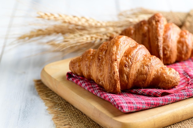 Homemade croissant on wood plate and white wood background bakery