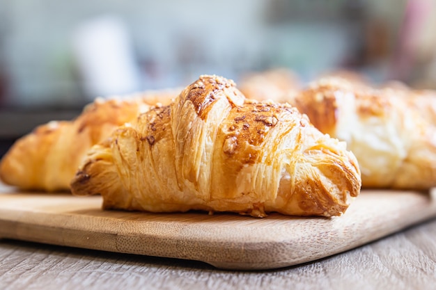 Homemade croissants with cheese on wooden board. Baking for breakfast.