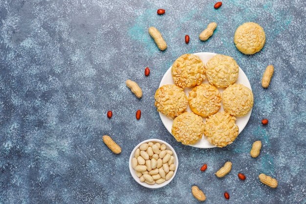 Homemade crunchy cookies with peanuts on grey, top view