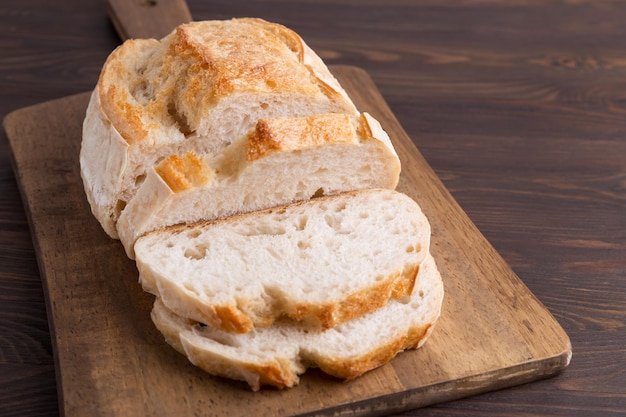 A homemade crusty loaf of bread on dark background