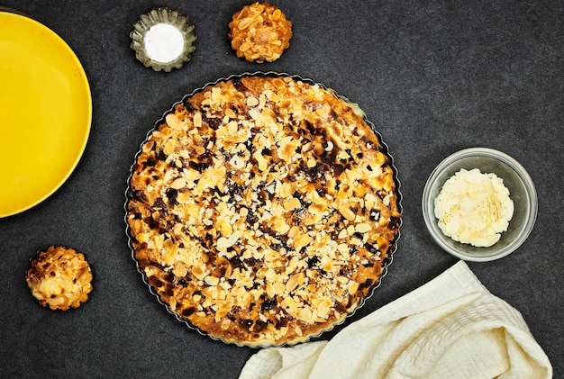 Homemade custard tart with almond flakes on grunge background