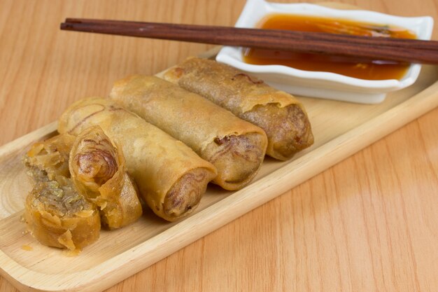 homemade deep fried spring rolls on a plate with sauce