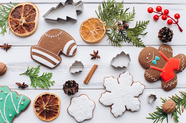 Homemade delicious Christmas gingerbread cookies on the white wooden background.