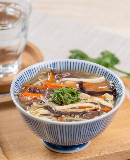 Homemade delicious Hot and Sour Soup in a bowl on a serving tray