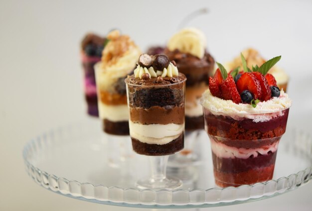 Homemade desserts in glass jars Traditional unbaked Italian dessert on a white background Cake with coffee berries fruits and mascarpone cream