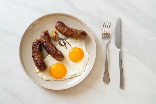 Homemade double fried egg with fried pork sausage - for breakfast