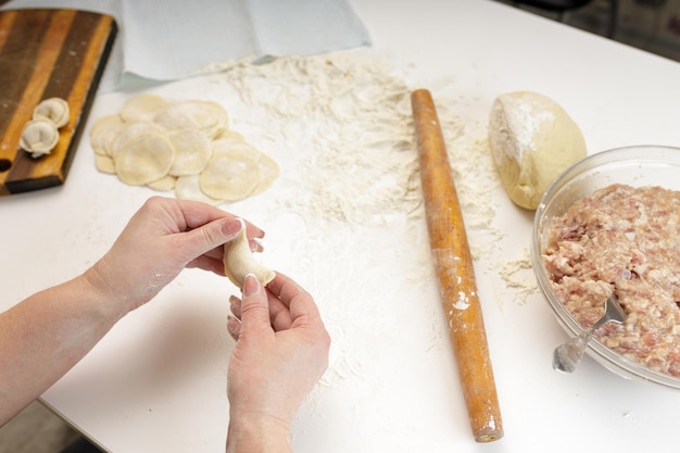 Homemade dumplings in the kitchen without decorations. making dumplings with minced pork, beef and chicken