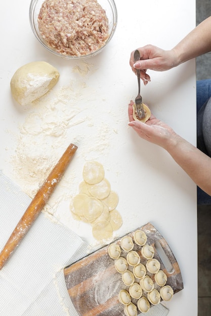 Homemade dumplings in the kitchen without decorations. making dumplings with minced pork, beef and chicken