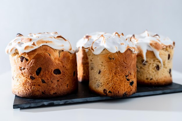 Homemade Easter cakes with white powder on a black stone stand on a light background Family values holidays with relatives