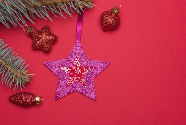 Homemade felt Christmas tree toy and glass Christmas toys on a red background