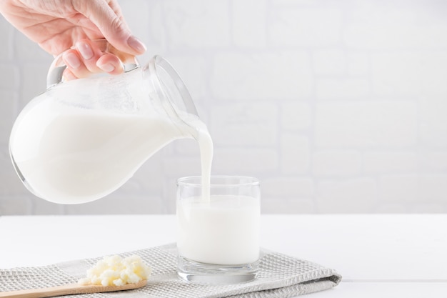 Homemade fermented beverage kefir with kefir grains in bowl on a white background, concept of natural fermented food and intestinal health