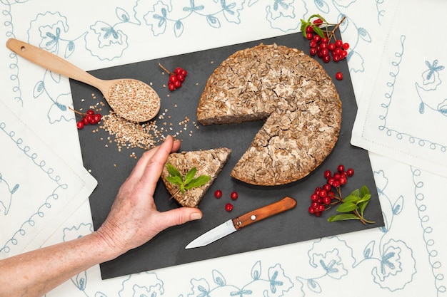 Homemade fermented green buckwheat bread with grandmother hand reach for piece